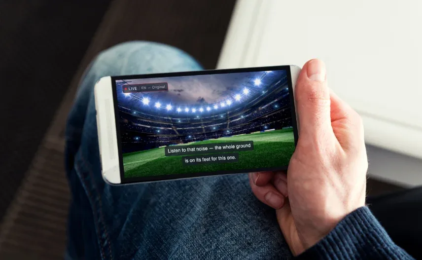 Viewer watching a live match on a phone with subtitles on screen